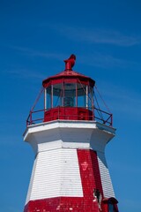Vertical shot of the Head Harbour Lightstation on a blue sky background in Campobello, New Brunswick