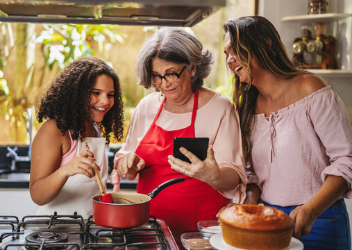 Av&oacute;, m&atilde;e e filha Brasilieiras na cozinha se divertindo enquanto preparam uma receita juntas para os dia das m&atilde;es