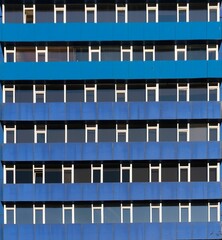 Exterior of a building with blue balcony barriers and many windows