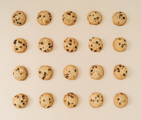Creative chocolate cookies pattern on pastel cream background. Minimal food concept. Yummy chocolate biscuits idea. Flat lay cookies composition. Top of view.