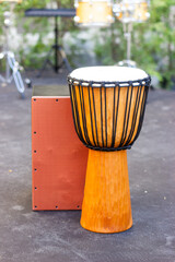 Percussion instruments. African hand carved djembe drum and wooden flamenco box drum.