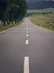 Vertical of an empty road surrounded by fields and trees