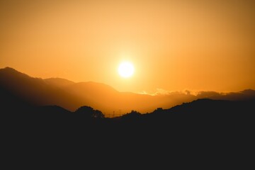 Silhouette of hills at bright orange sunset