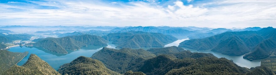 Fototapeta na wymiar Panoramic shot of the landscape of tree hills between the lake in Taizhou
