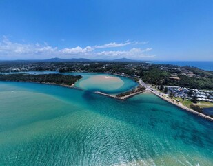 Drone view of the sandy beach of the azure sea against the trees