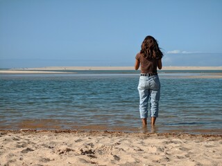Young woman standing on the beach of Obidos Lagoon, Portugal