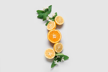 Lemons and orange with blooming branches on grey background