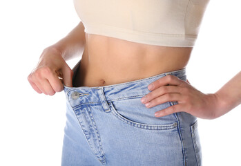 Young woman in loose jeans on white background. Diet concept