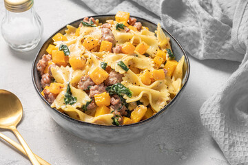 Autumn pasta farfalle with sausage, spinach and pumpkin