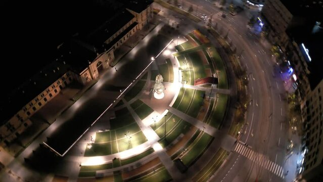 Aerial view of a curving road in front of an ancient building at night