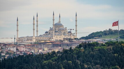 Fototapeta na wymiar Big Suleymaniye Mosque in Istanbul and the flattering flag of Turkey on a pole against the blue sky