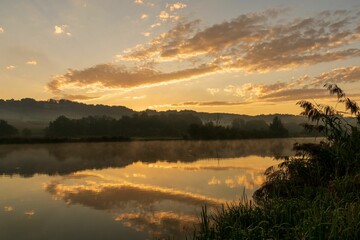 Fototapeta na wymiar Cloud reflection on the water at sunrise