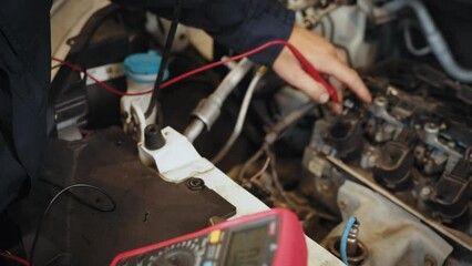 Man using multimeter to measure the voltage of the batteries. Mechanic doing car inspection, he is testing car battery with tester. Check battery voltage with electric multimeter