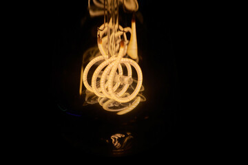 long tube-shaped Edison lamp, bulb, black background.