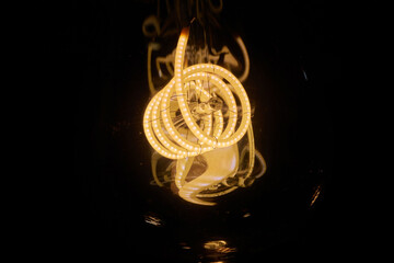 long tube-shaped Edison lamp, bulb, black background.