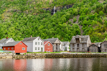 Fototapeta na wymiar A typical Norwegian falu red wooden cottages by a pond. Beautiful mountain scenery.
