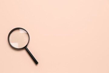 Black magnifier on pale pink background