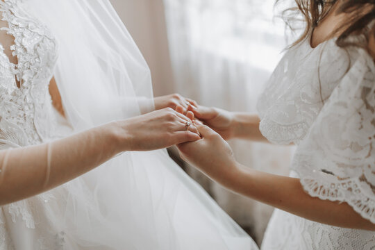 Morning of the bride. The bridesmaid helps the bride, supports her and holds her hands. Girlfriends help the bride.