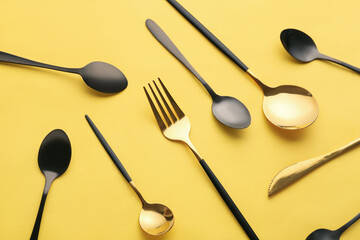 Stylish cutlery on yellow background