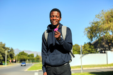 black African man smiling holding flowers