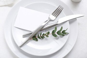 Stylish table setting with blank card and plant branch on white background