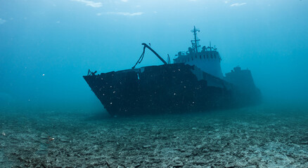 destroyed ship under the deep sea on the dirty sand - obrazy, fototapety, plakaty
