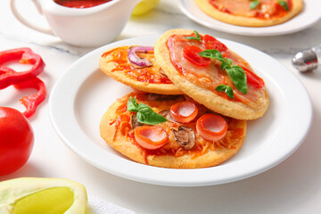 Plates with different tasty mini pizzas on white background