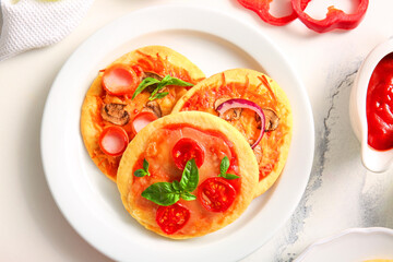 Plate with different tasty mini pizzas on white background