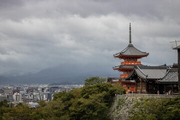 Buddhist temple, Kiyomizu-dera in Kyoto, Japan, surrounded by green trees on a cloudy day