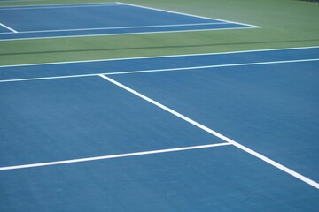 Landscape of a blue and green tennis court on a sunny day