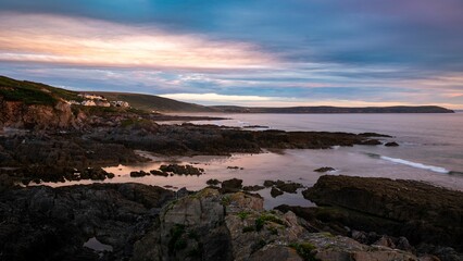 Horizontal view of Woolacombe beach, surrounding cliffs and nature under the blue sky in July 2022