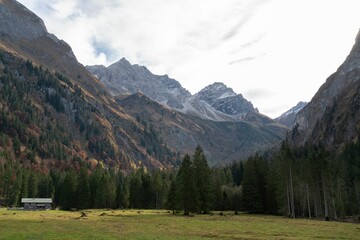 Aerial view of lush green valley surrounded by steep rocky mountains in Oberstdorf, Germany