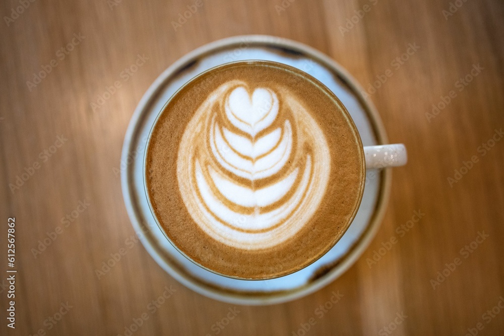 Sticker Top view of fresh cappuccino on a wooden table