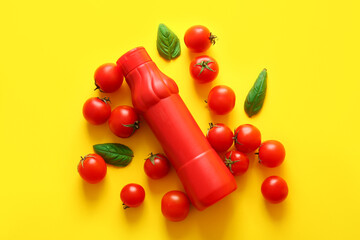 Bottle of ketchup and tomatoes on yellow background