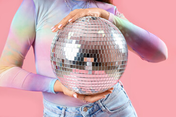 Fashionable beautiful woman with disco ball on pink background