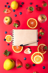 fruits and berries on a red background. Notepad for text. Flying freshness. View from above. copyspace.