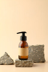 Amber glass pump bottle with blank label on stone podium. Natural cosmetic product design, branding