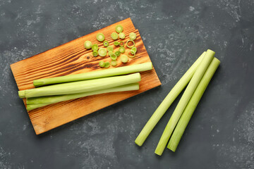 Board with fresh leeks on dark background