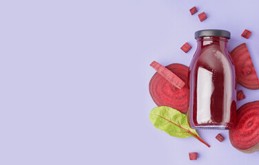 Bottle of healthy beet juice and spinach on lilac background
