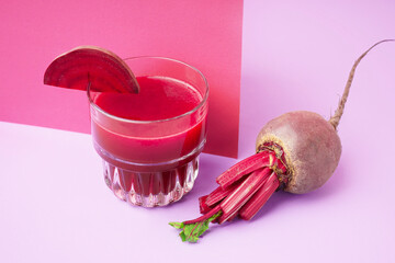 Glass of healthy beet juice on colorful background