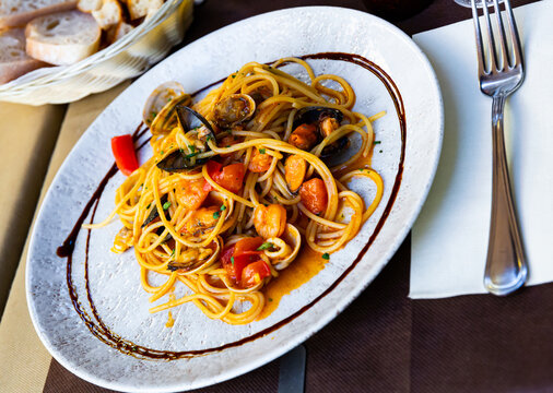 Image of delicious spaghetti of shrimps, mussels and vegetables at plate