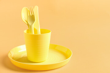 Different eating utensils for baby on pale orange background