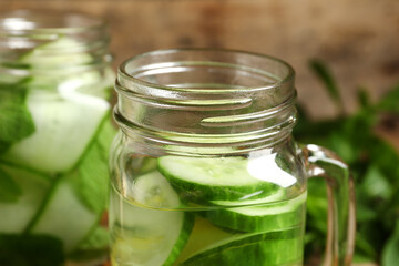 Mason jars of infused water with cucumber slices, closeup