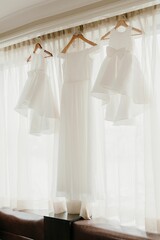 Selective of a bride's dress hanging in a room