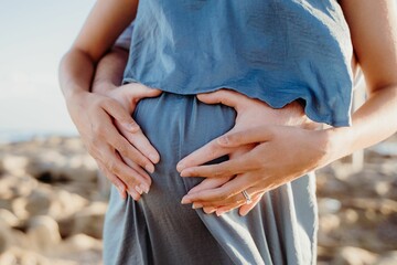 Closeup shot of a husband and pregnant wife posing together at a maternity shoot