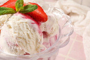Bowl of vanilla ice cream with strawberries and mint on pink tile table, closeup
