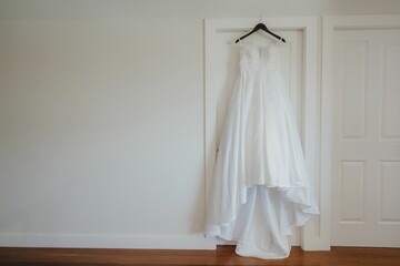 White elegant wedding dress hanging in the room