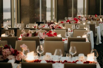 Beautiful shot of dinner tables with floral decorations and candles at a wedding venue