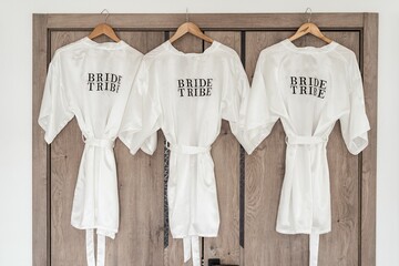 Closeup of three white Bride tribe robes on hangers