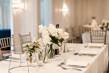 Table decorated with beautiful white flowers and candles on a wedding party